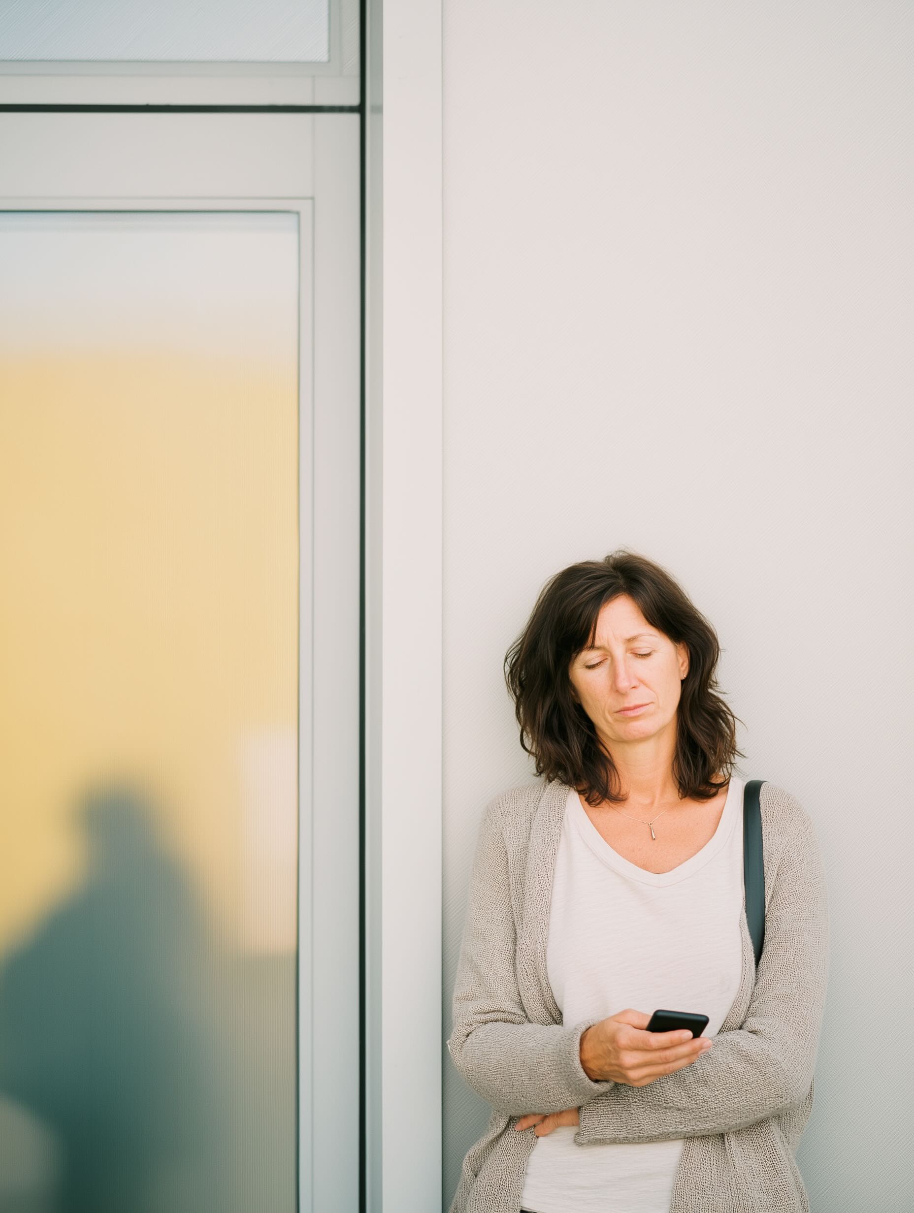 Woman outside a clinic, looking at her phone